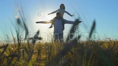 父子玩耍的<strong>剪影</strong>，日落时分在麦田里的飞机臂一起举起，幸福的一家人散步